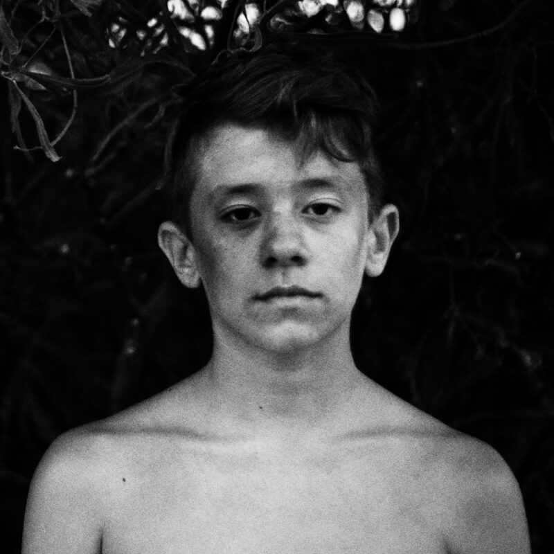 Black and white fine art photograph of an adolescent boy by Eleni Onasoglou.