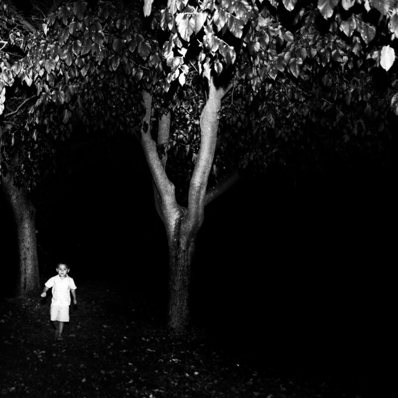 Black and white fine art photograph of a boy as a dark silhouette by Eleni Onasoglou.