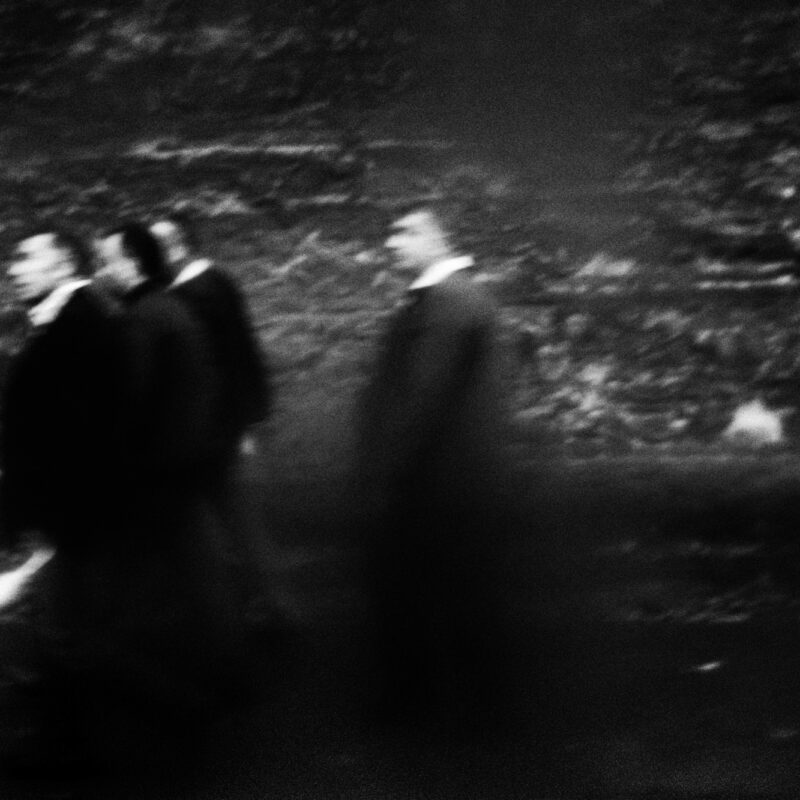 Atmospheric black and white photograph of figures in a dark landscape by Eleni Onasoglou.